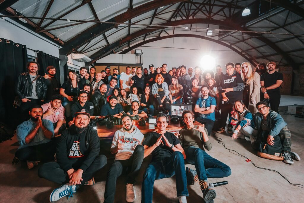 A happy and diverse group posing together in a São Paulo warehouse setting.